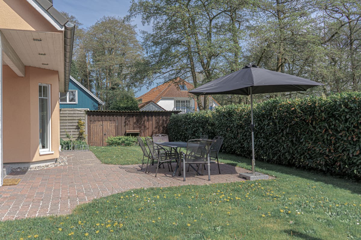 Gartenanteil mit Rasen, Hecke und Blick auf die Hausrückseite